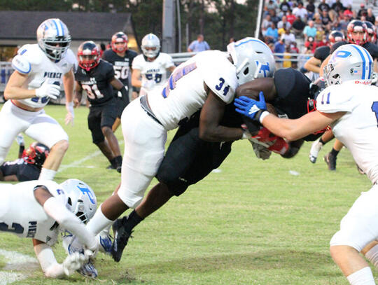 <p>Bear defenders JaQuez White (2), Trent Moody (34) and Wade DiBiase (11) tackle a Charlton County runner in the Bears win Friday night.</p>