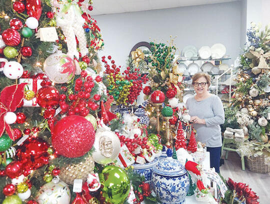 <p>Mary Claire Boatright stocks the Christmas section at The Barnard Company in Patterson as Christmas shopping season begins</p>