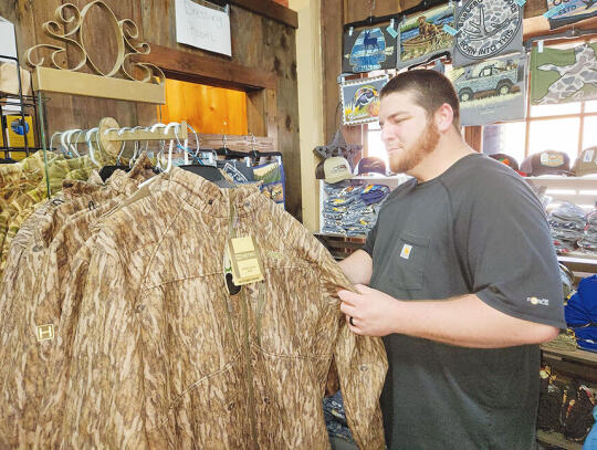 <p>Victor Henderson looks over the HeyBo® camo clothing at Michelle’s on Main in Blackshear.</p>