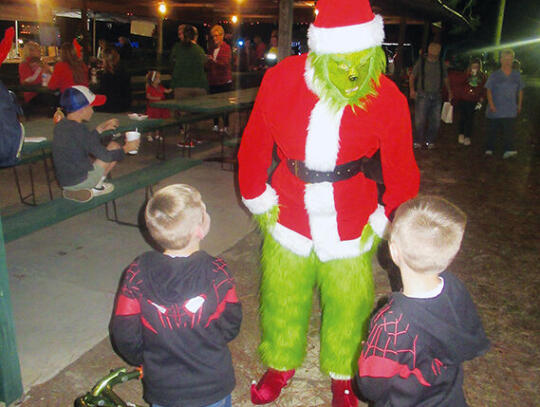 <p>Twin brothers, Aiden and Asher Farmer, 5, talk to the Grinch.</p>