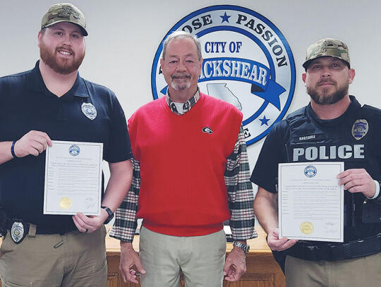 Blackshear Police Officers Jacob Goble (left) and Jason Ragsdale (right) are credited with saving the life of Donnie Simmons, after he was seriously injured in an accident at home. Goble and Ragsdale were honored at a recent meeting of the Blackshear City Council. They are shown with Black...