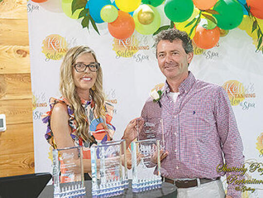 Cassie Davis, Chamber Executive Director, (left) presents the Huel P. Walker Educator of the Year award to John Ratliff (right).