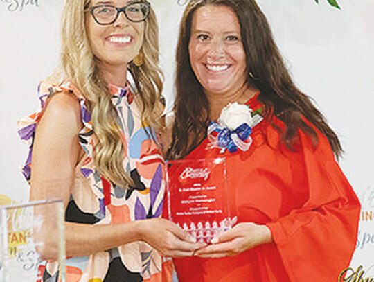 Cassie Davis, Chamber Executive Director, (left) presents the S. Dow Nimmer award to Malayna Wetherington (right).